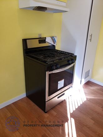 an oven in the corner of a room with a wooden floor
