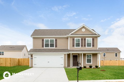 a beige house with a garage and a lawn