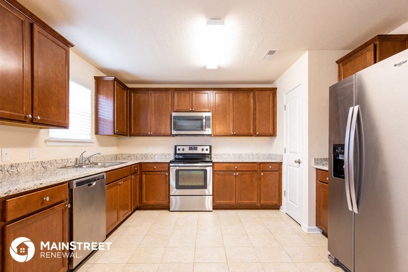 a kitchen with wooden cabinets and stainless steel appliances