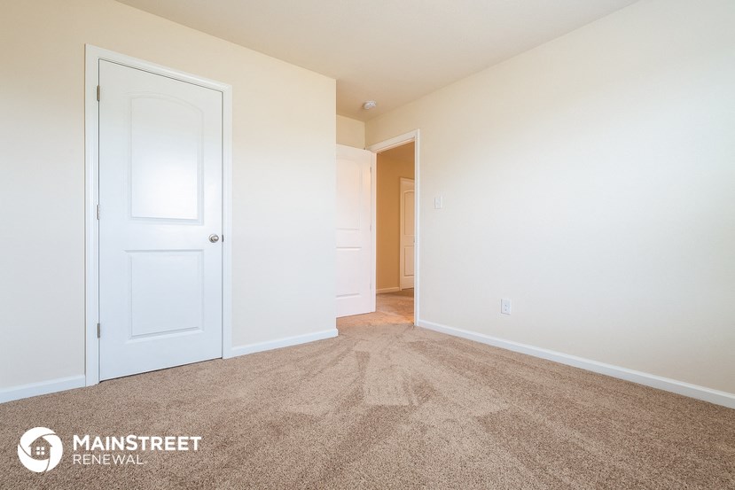 a bedroom with a closet and a door to a hallway