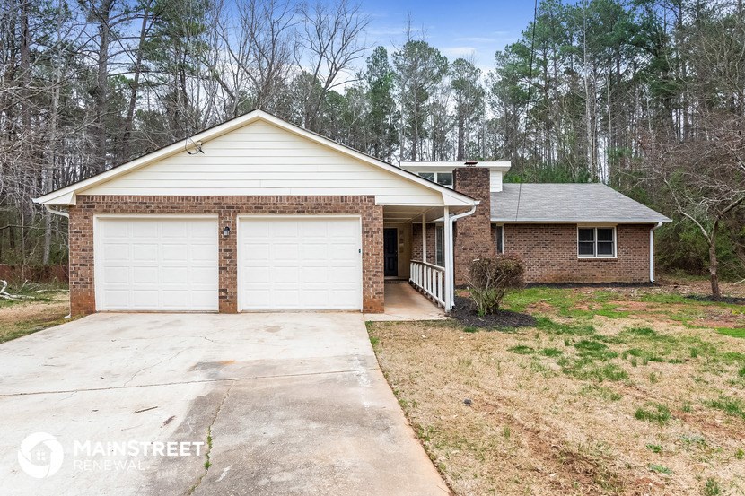 a brick house with a white garage door and a driveway
