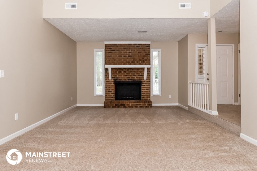 the living room of an empty house with a fireplace