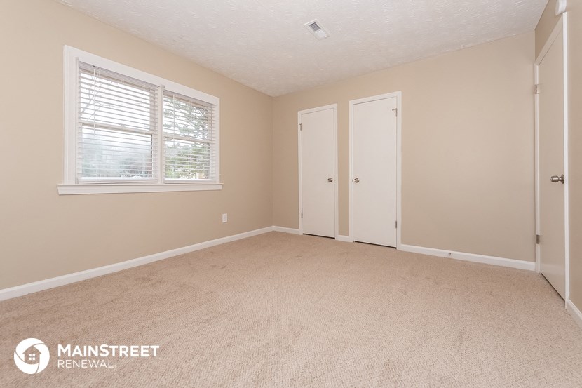 the living room of a home with a carpeted floor and a window