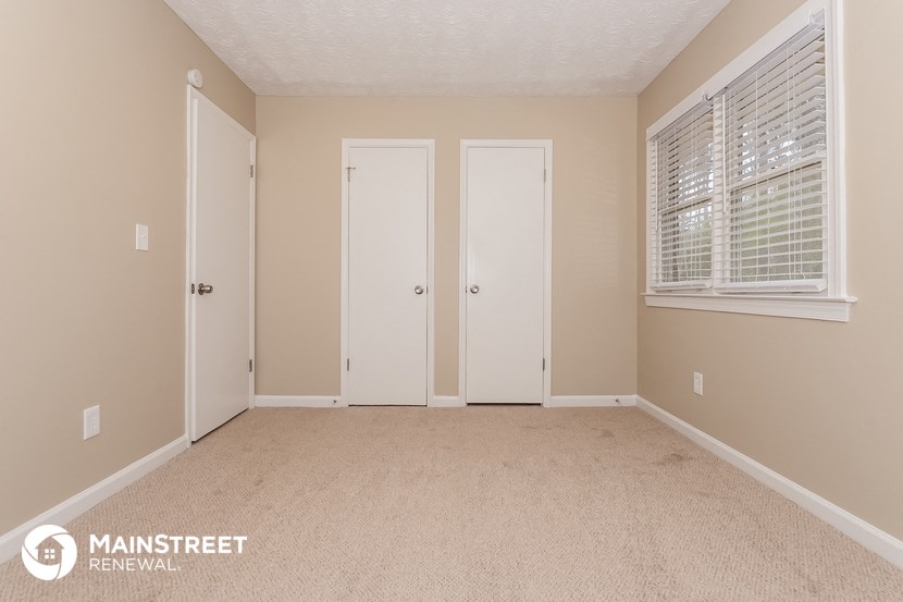 the upstairs bedroom has a carpeted floor and two closet doors