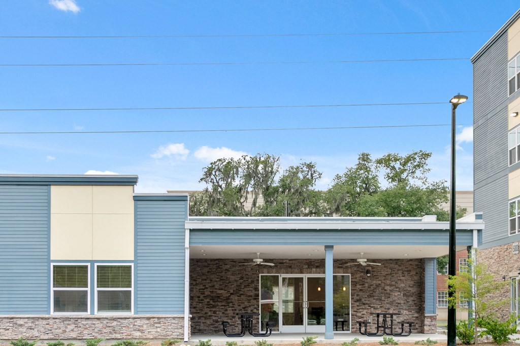 the front of a building with a porch and a blue sky
