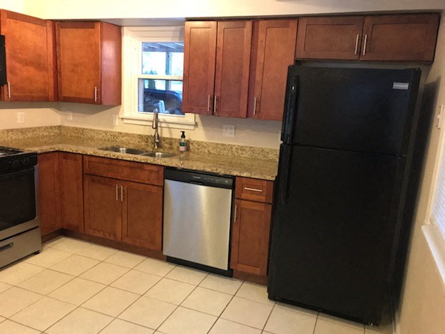 a kitchen with a black refrigerator and a sink