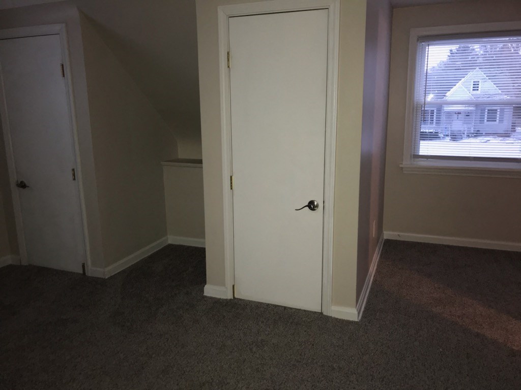 a white door in a room with a window