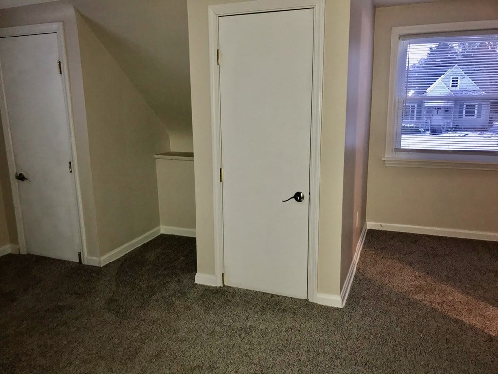 a room with a door and a window and a closet