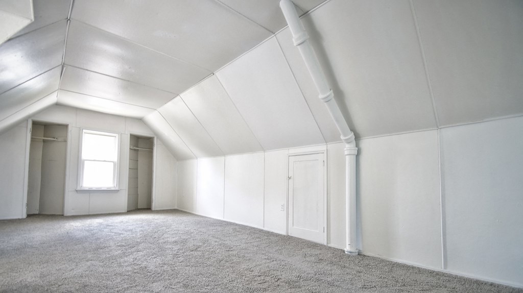 an empty room with white walls and a window