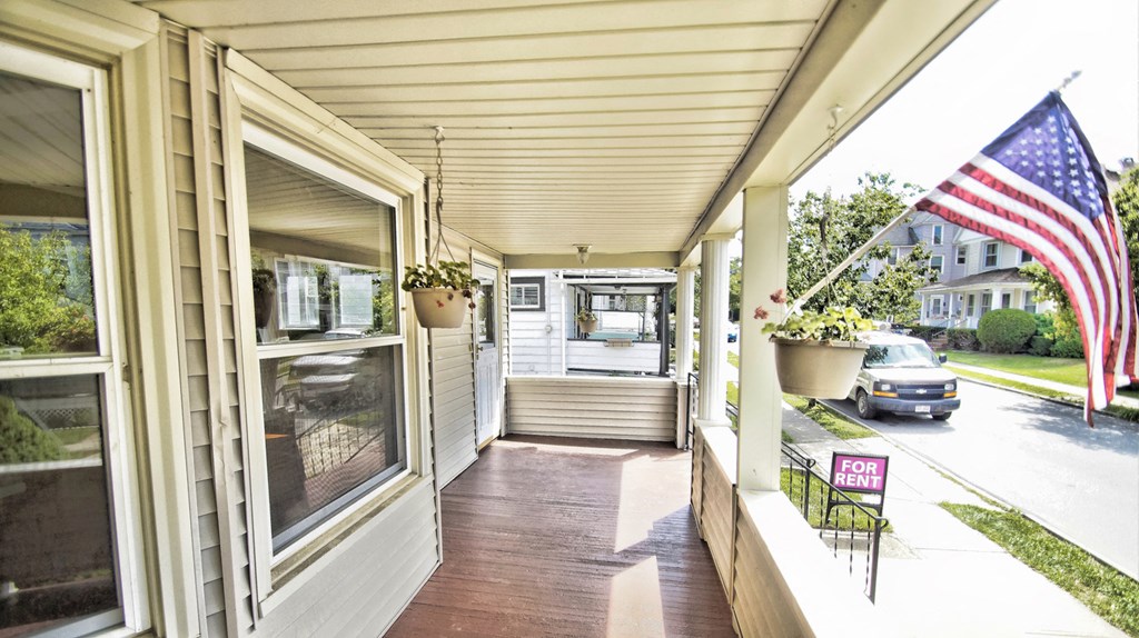 the front porch of a home with an flag