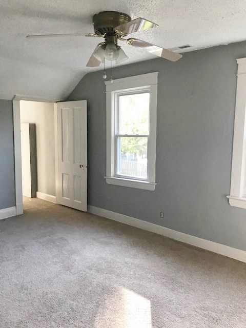 an empty room with a ceiling fan and a window