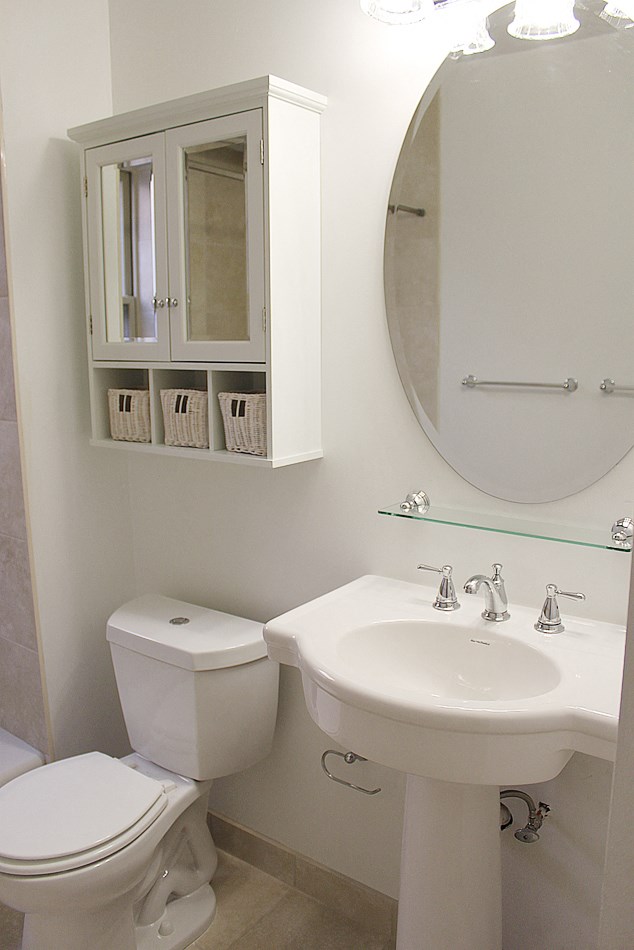 a white bathroom with a sink toilet and a mirror