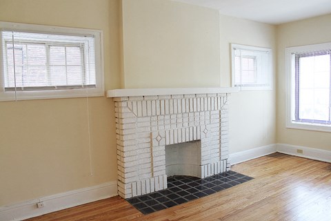 an empty living room with a fireplace and a window