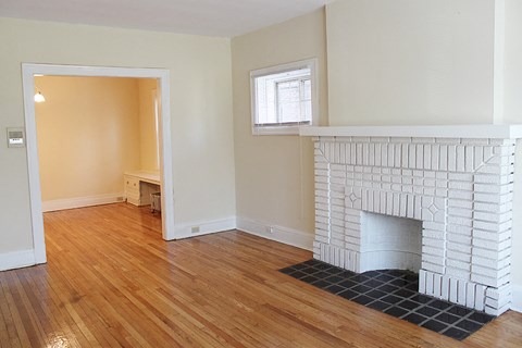 a living room with a fireplace and a wooden floor