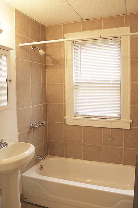 a bathroom with a tub and a sink and a window