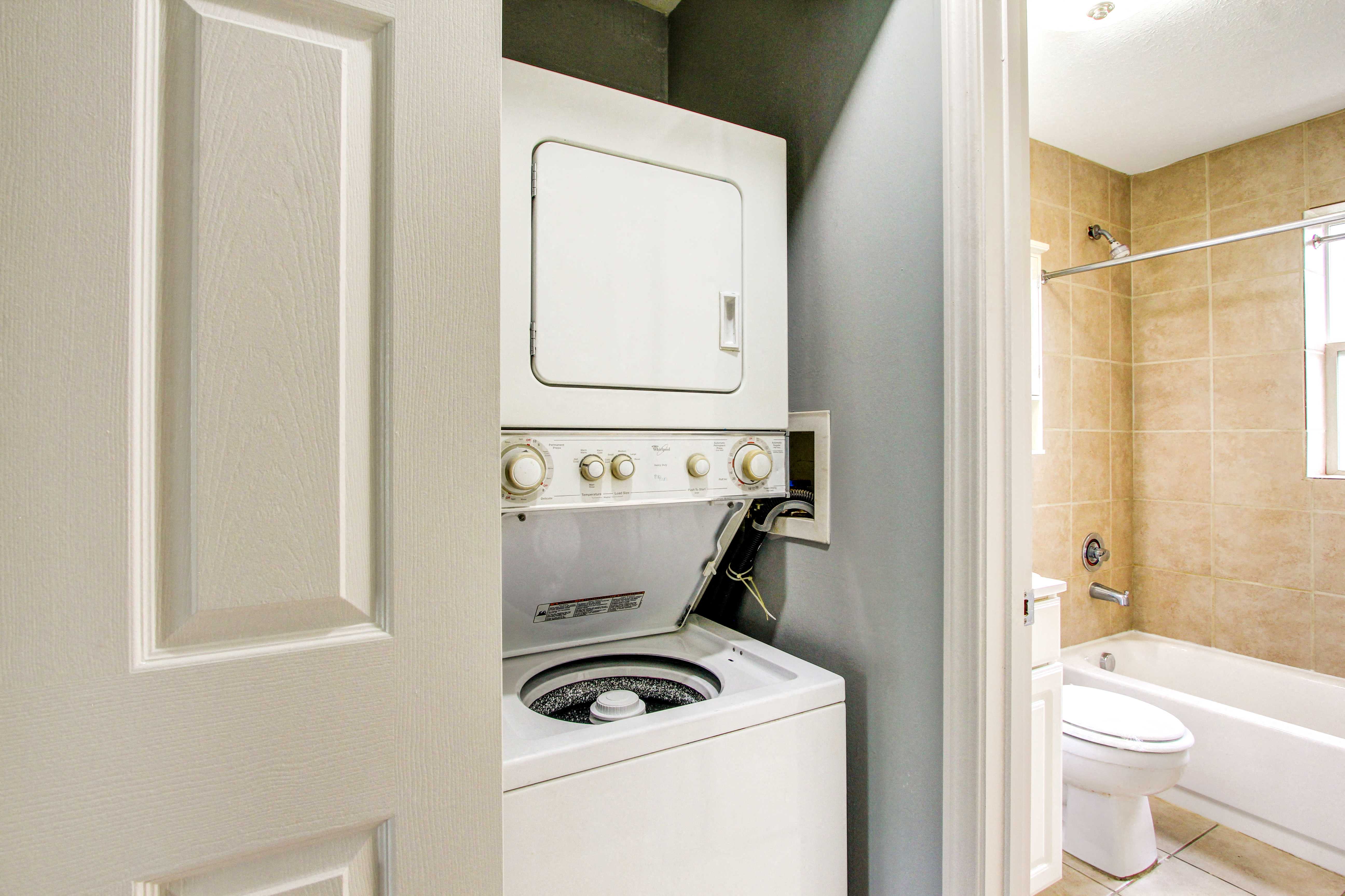 a laundry room with a washer and dryer and a bathroom with a toilet