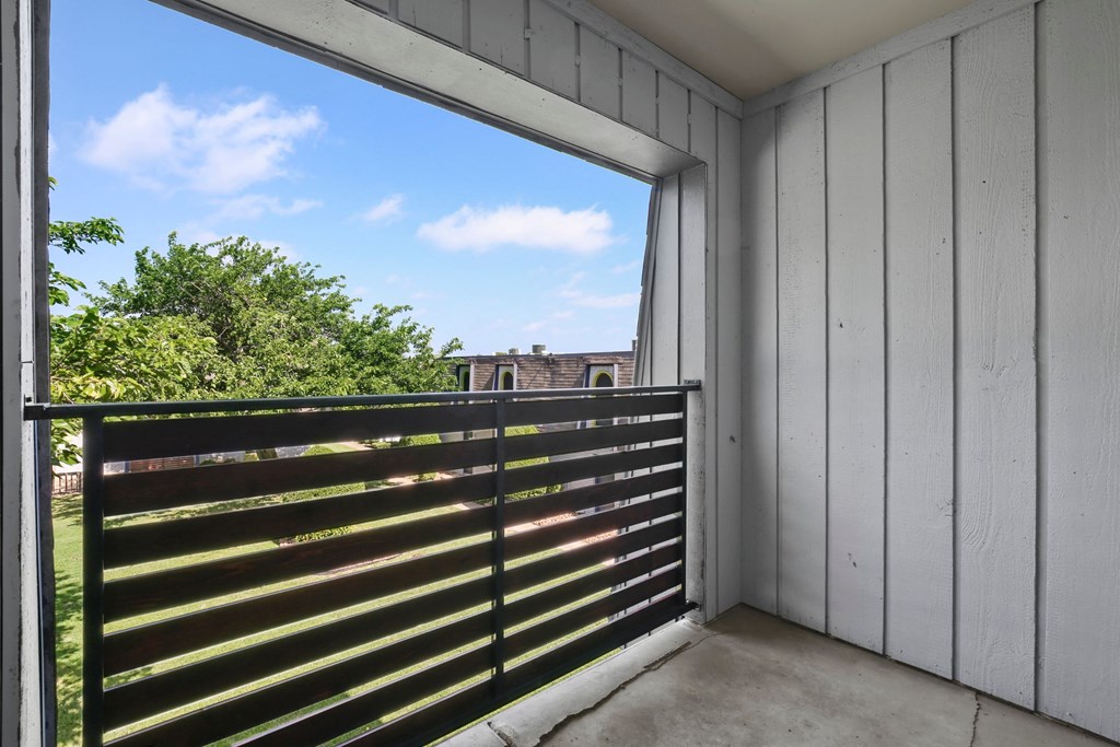 a balcony with a fence and a view of a building