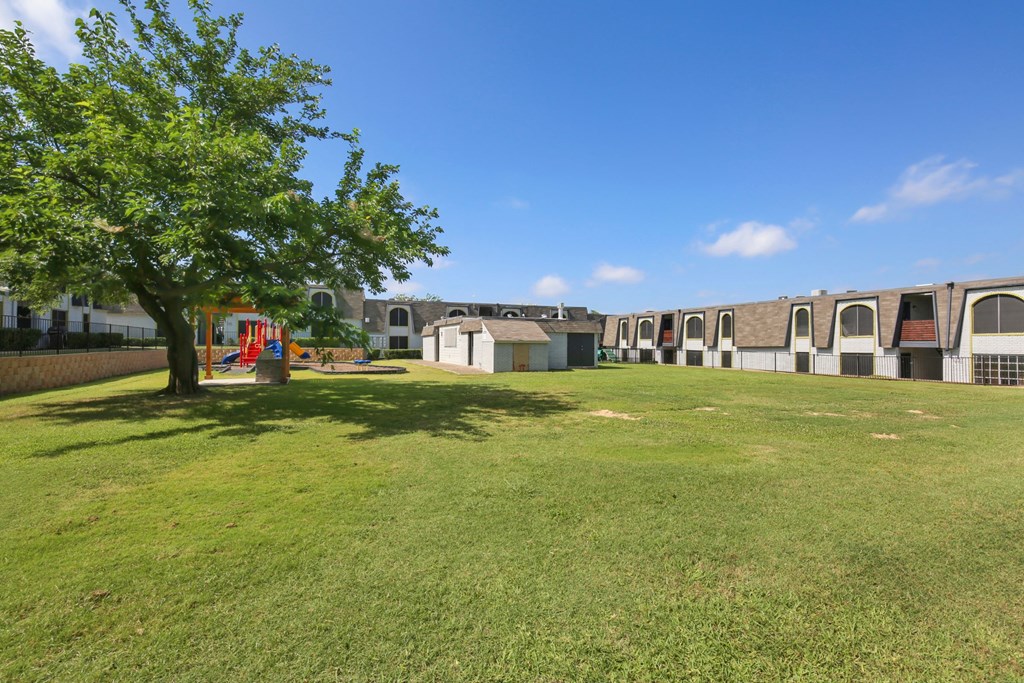 a group of houses in a yard with a tree