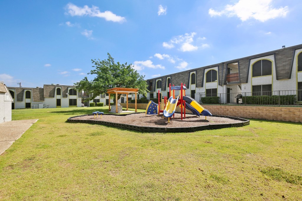 a playground in the yard of an apartment complex