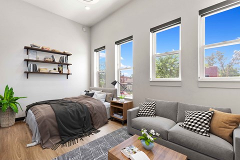 A bedroom with a bed, a couch, and a coffee table.