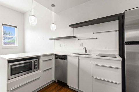 A modern kitchen with stainless steel appliances and white cabinets.