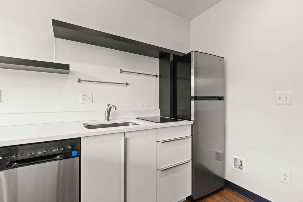 A modern kitchen with stainless steel appliances and white cabinets.
