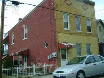 a red and yellow building with a car parked in front of it