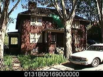 A white car is parked in front of a house.