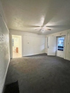 an empty living room with a ceiling fan