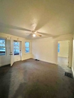 an empty living room with a ceiling fan