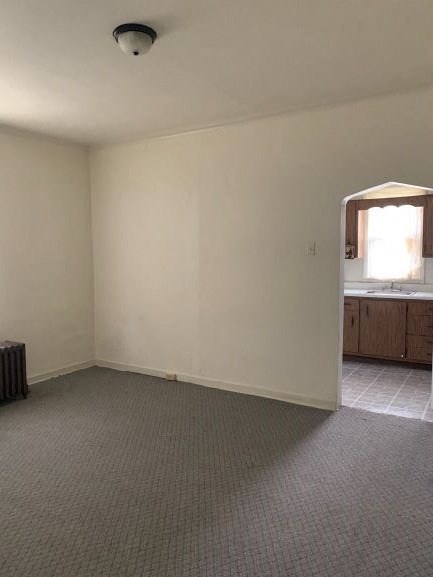an empty living room with a sink and a window