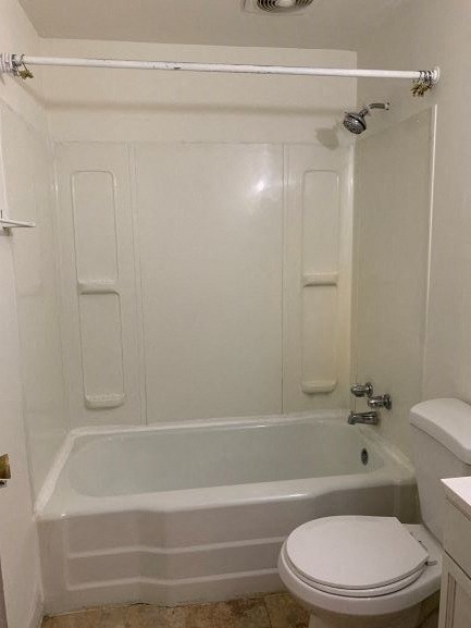 a white bathroom with a toilet and a bath tub