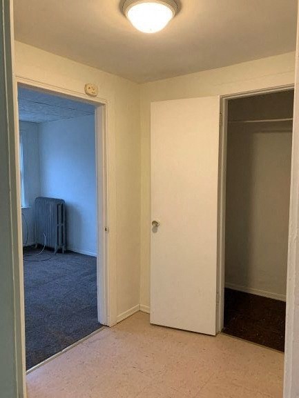 an empty room with a door open to a bedroom