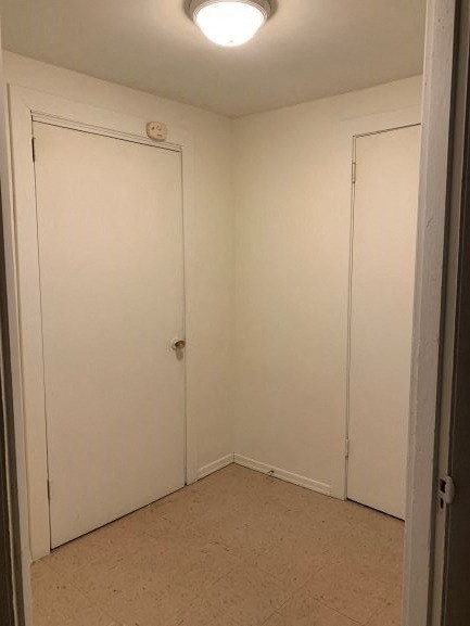 a white room with two doors and a light on the ceiling