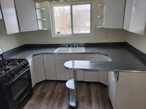 A kitchen with white cabinets and a black stove top oven.
