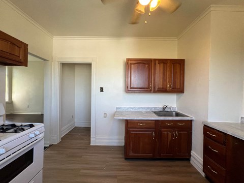 A kitchen with wooden cabinets and a white stove top oven.