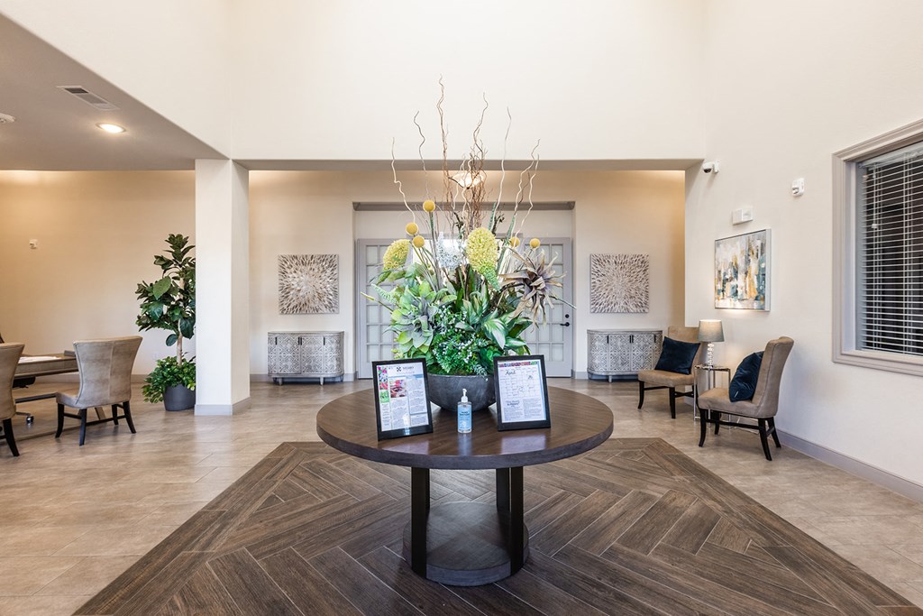 a lobby with a table with a flower arrangement on it