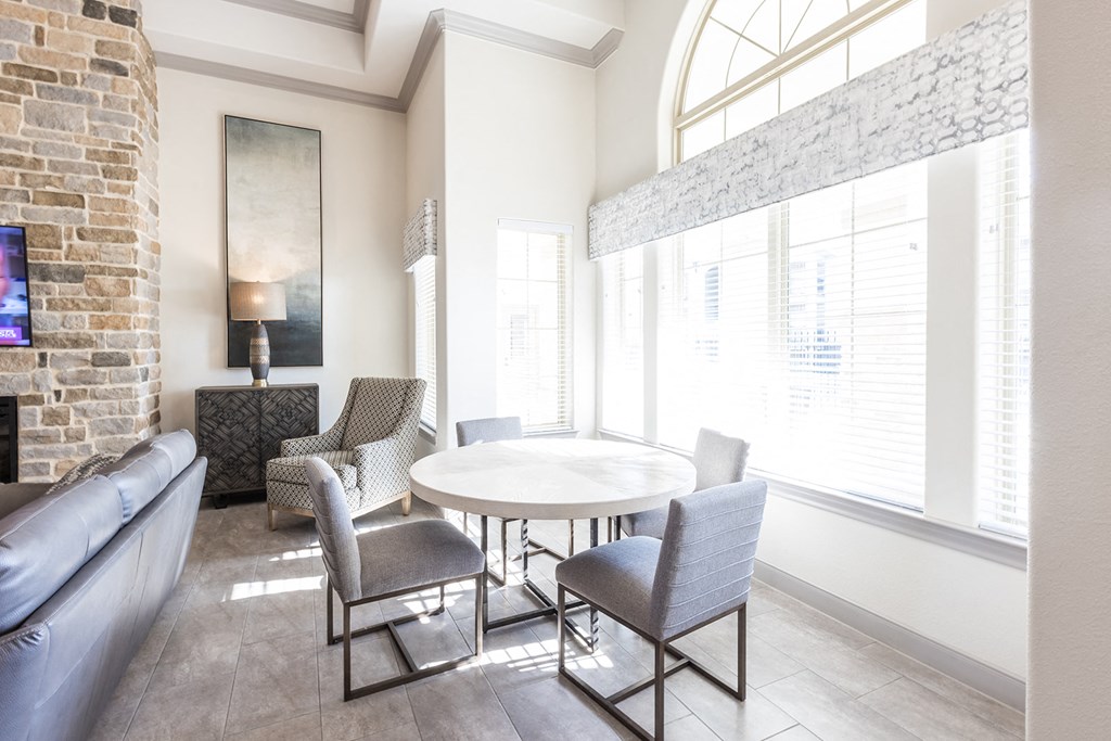 a living room with a table and chairs and a large window