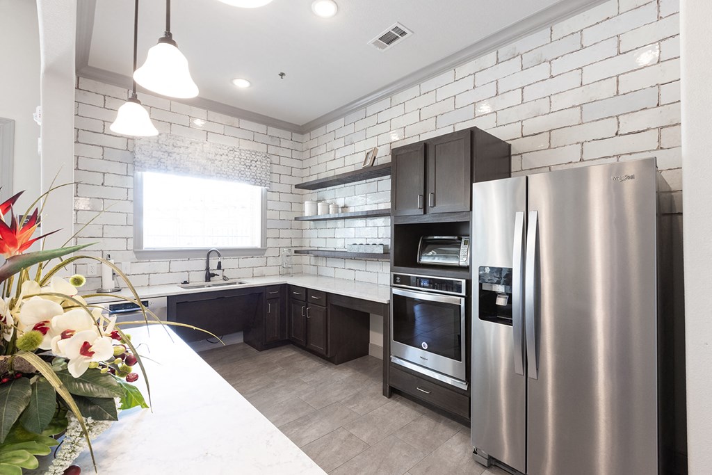 a kitchen with stainless steel appliances and white brick walls