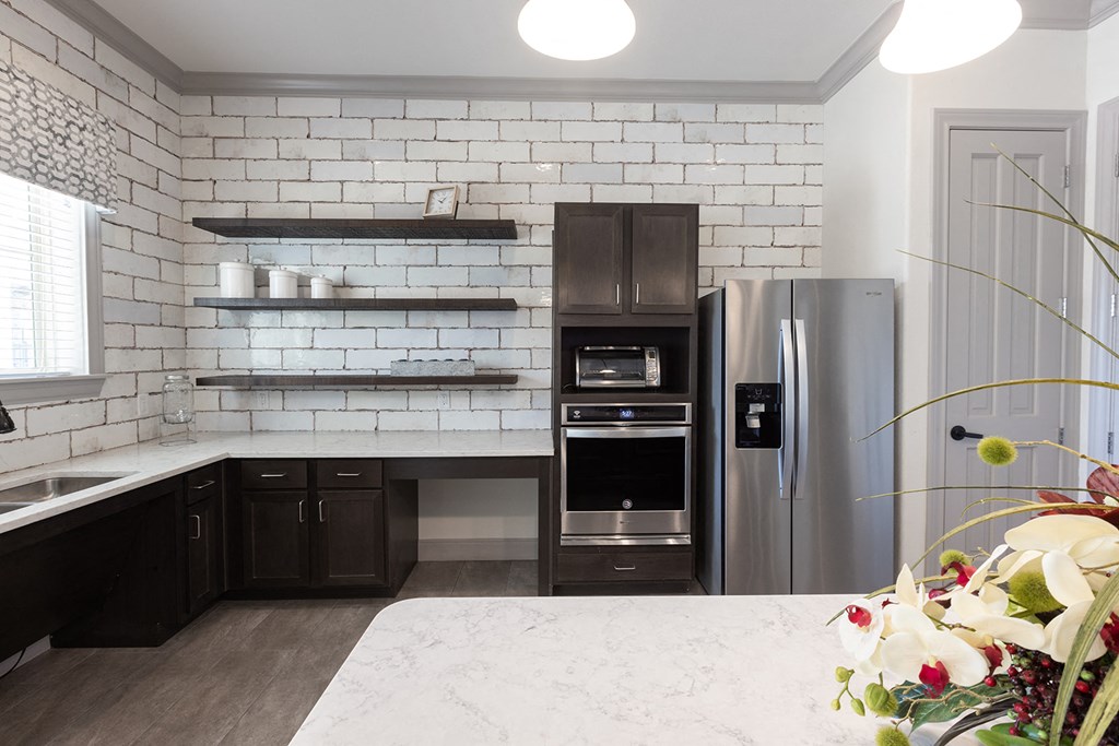 a white kitchen with black cabinets and stainless steel appliances