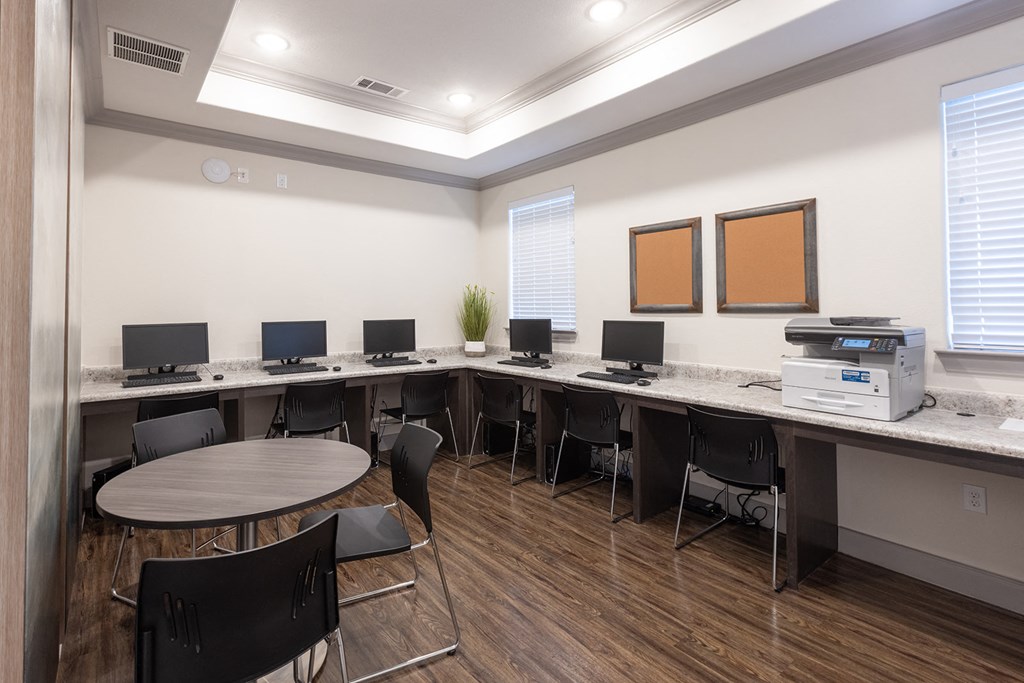 a computer room with desks and chairs and a printer