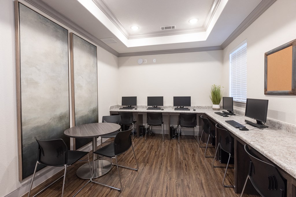 a computer room with desks and chairs and monitors