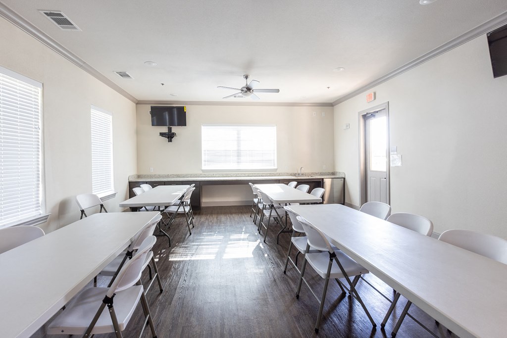 a conference room with tables and chairs and a ceiling fan
