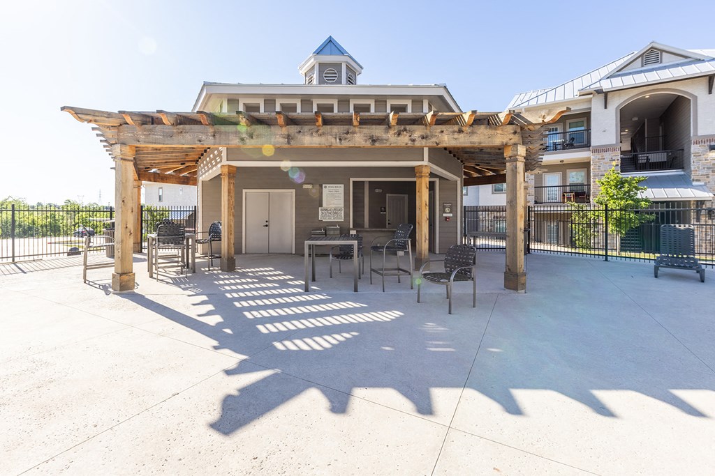 a patio with tables and chairs in front of a building