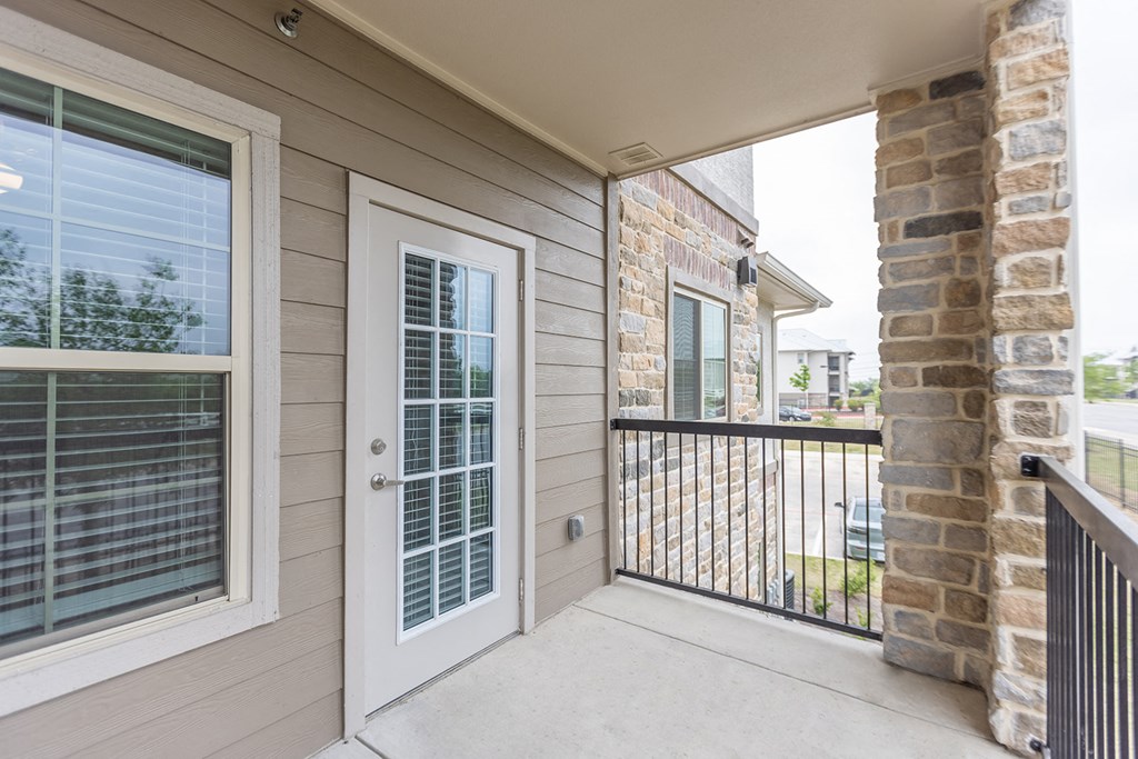 the porch of a home with a glass door and a railing