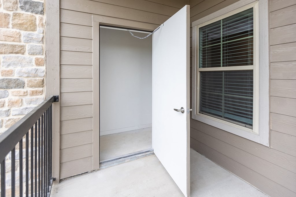 the front door of a home with a window and a porch