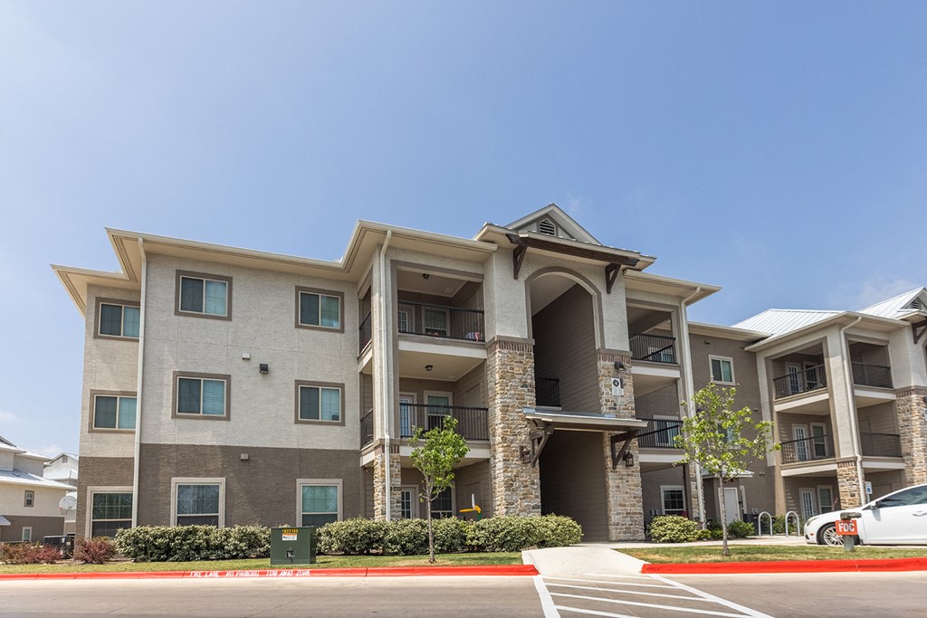 an apartment building with a car parked in front of it