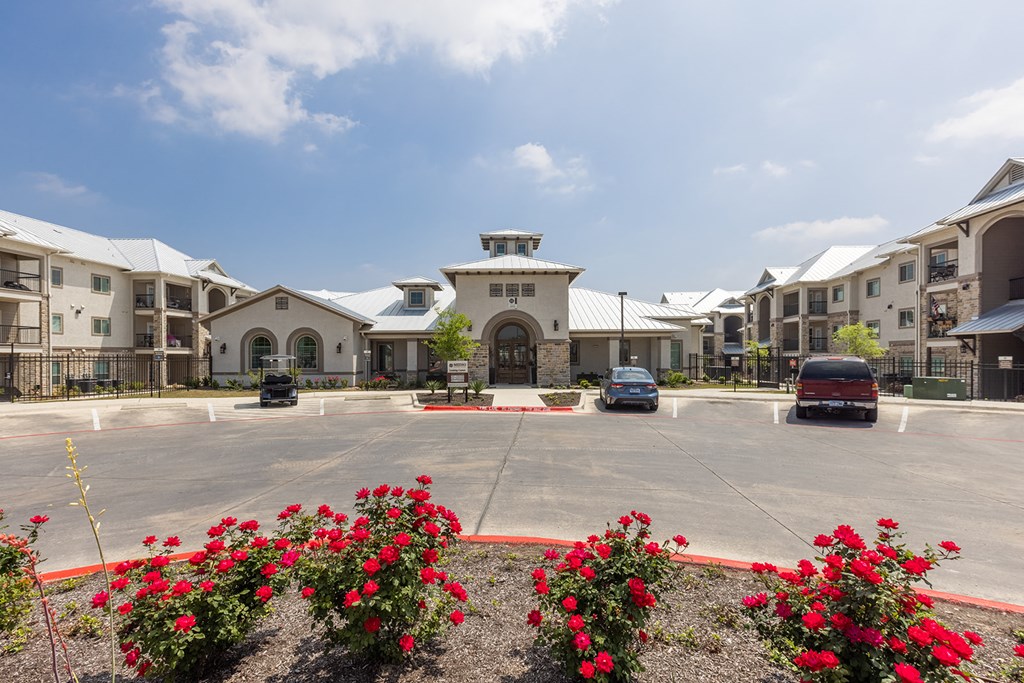 an empty parking lot with cars in front of an apartment building
