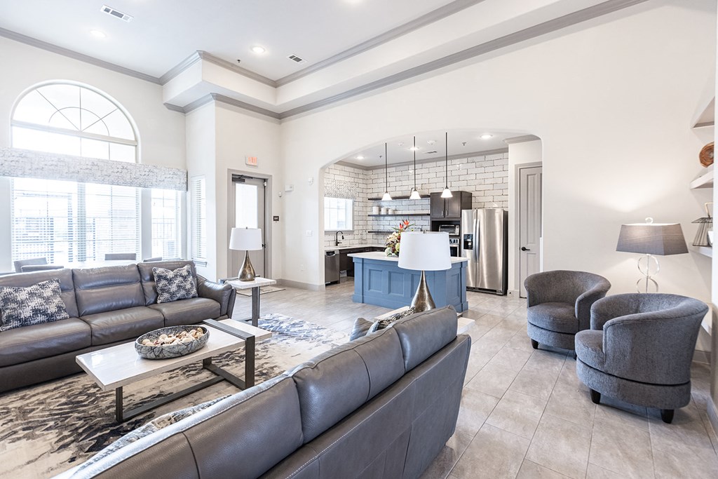 a living room with couches and chairs and a kitchen
