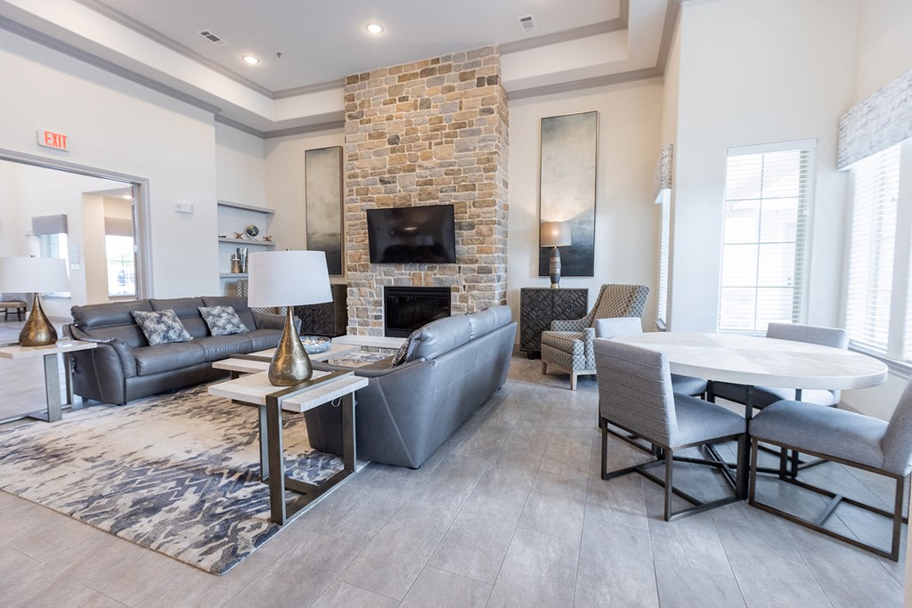 a living room with couches a table and chairs and a fireplace